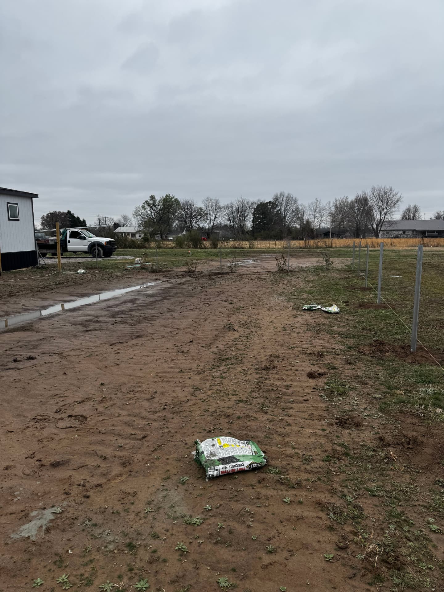 Metal fence posts set along a property beside a manufactured home