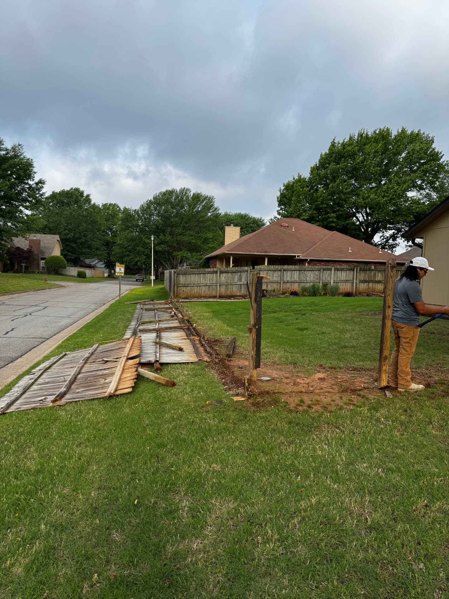 Wood fence removal in progress along a residential corner lot