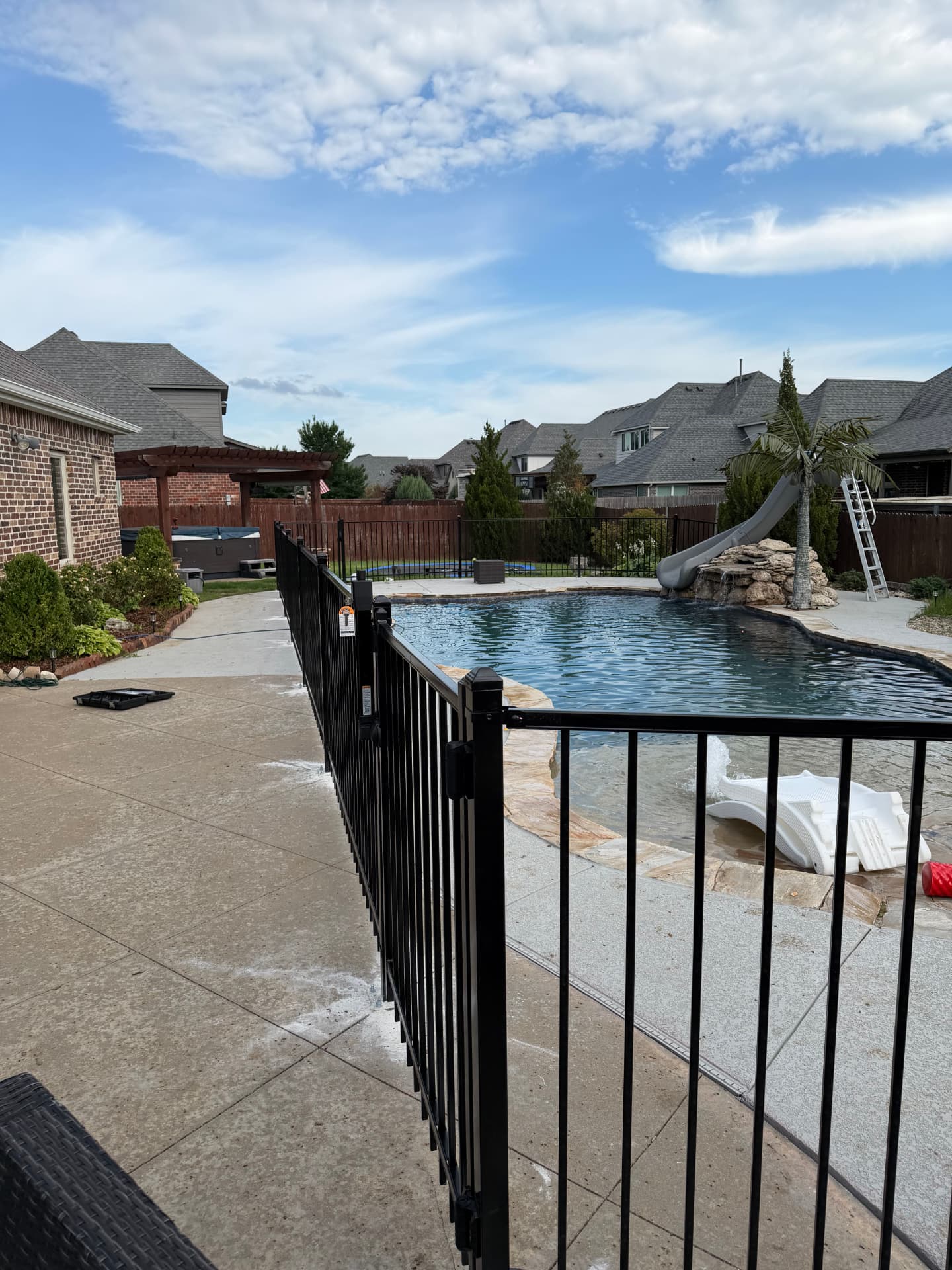 Black metal fence installed around a backyard swimming pool